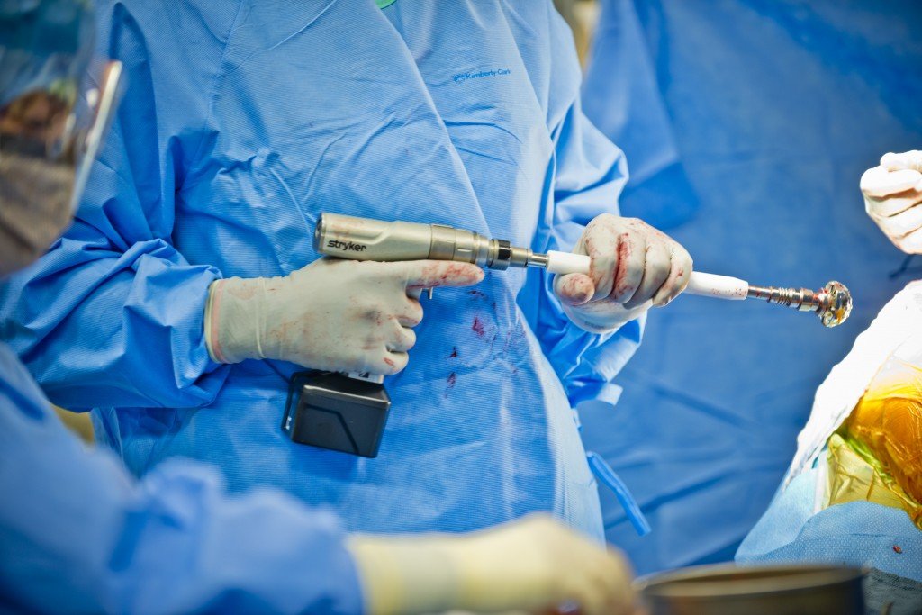 Lt.-Col.-John-Cletus-Paumier-holds-a-grater-reamer-while-performing-hip-replacement-surgery